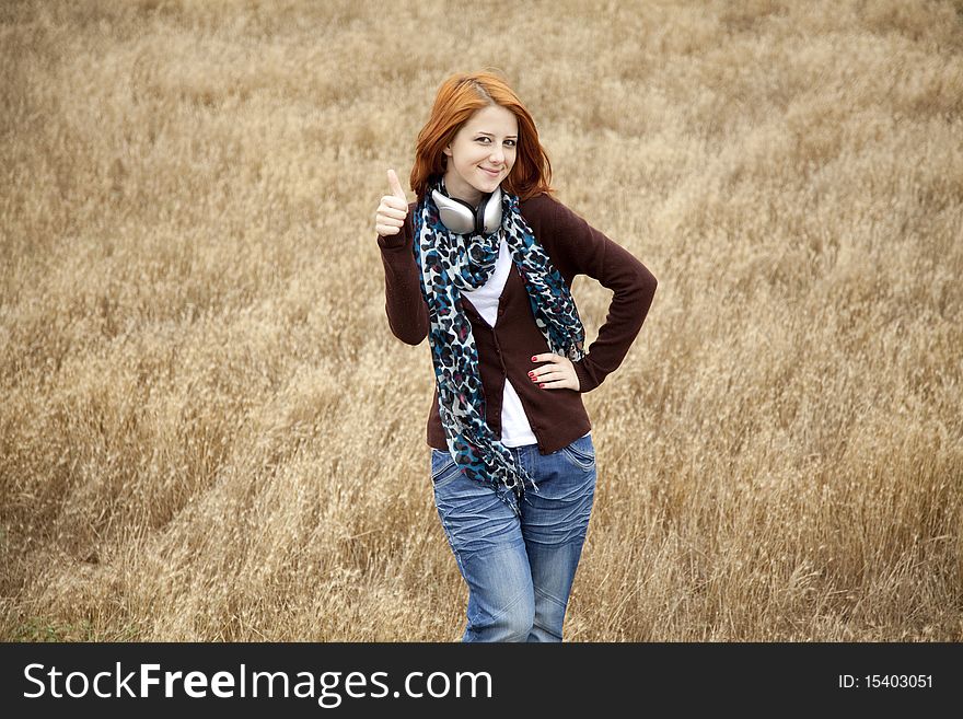 Young  smiling fashion with headphones at field. Outdoor photo.