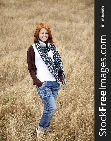 Young girl with headphones at field. Outdoor photo.