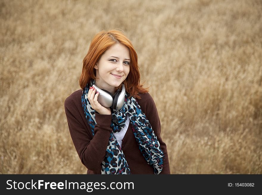 Young girl with headphones at field.