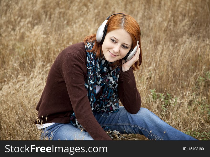 Young girl with headphones at field.