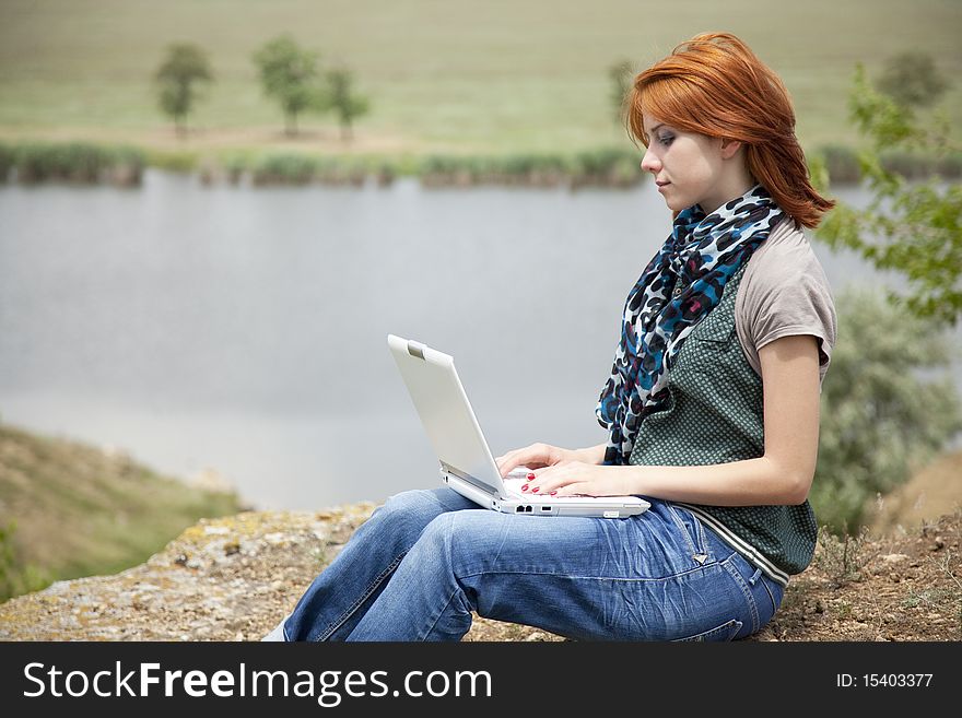 Young Girl With Laptop At Rock Near Lake