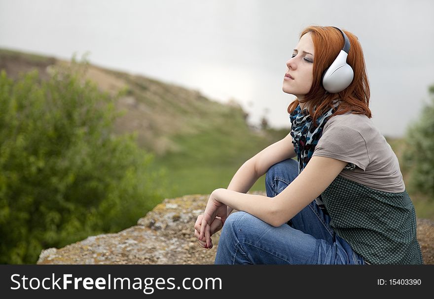 Young girl with headphones at rock