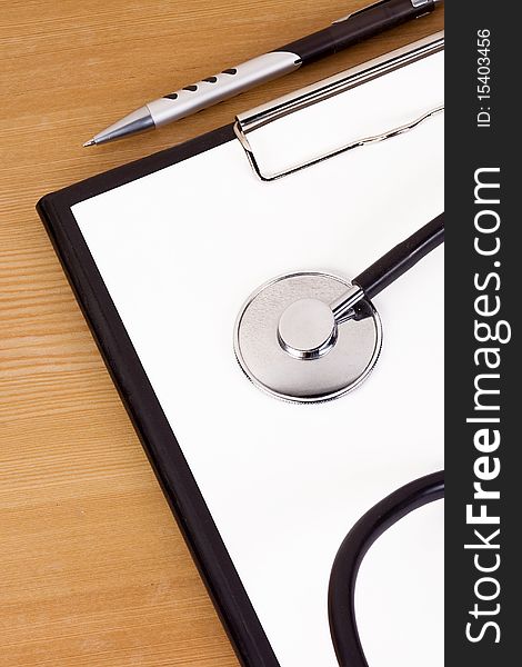 Black stethoscope and paper on table