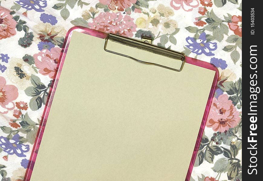 Blank page on pink feminine clipboard on floral background for school or business