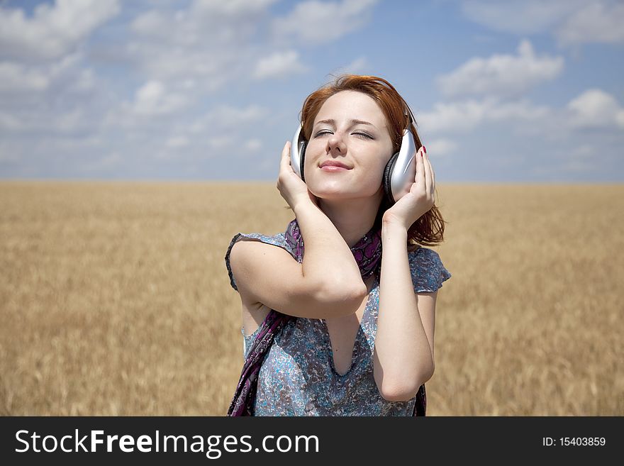 Young smiling fashion with headphones at wheat field. Young smiling fashion with headphones at wheat field.
