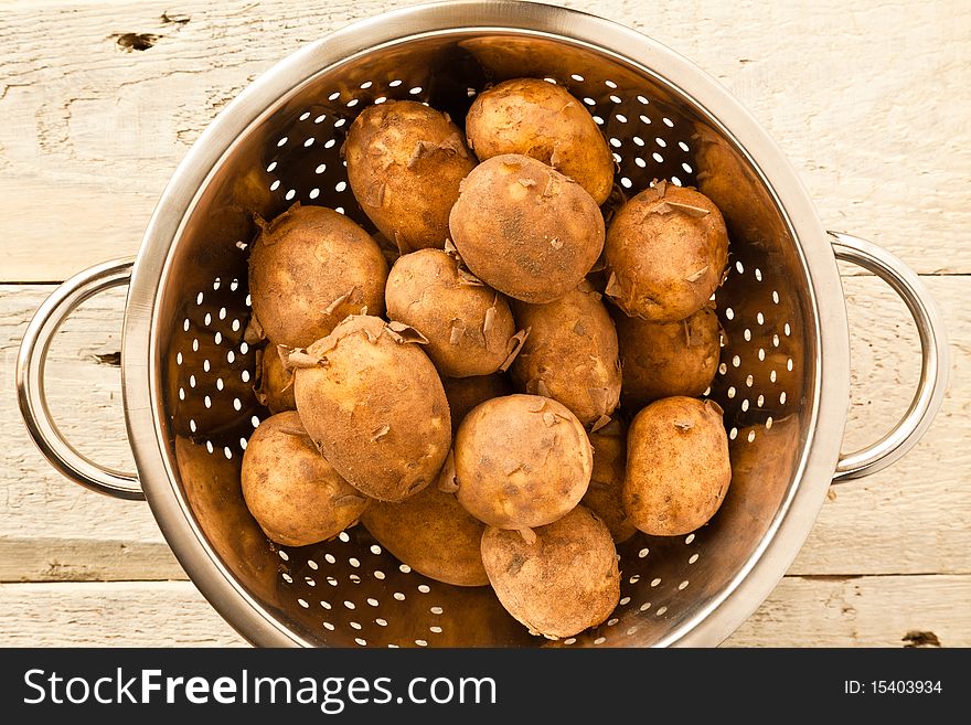 Unwashed new potatoes in a colander