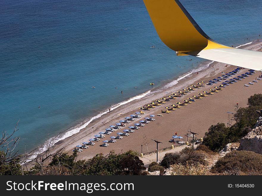 Airplane wing over beach