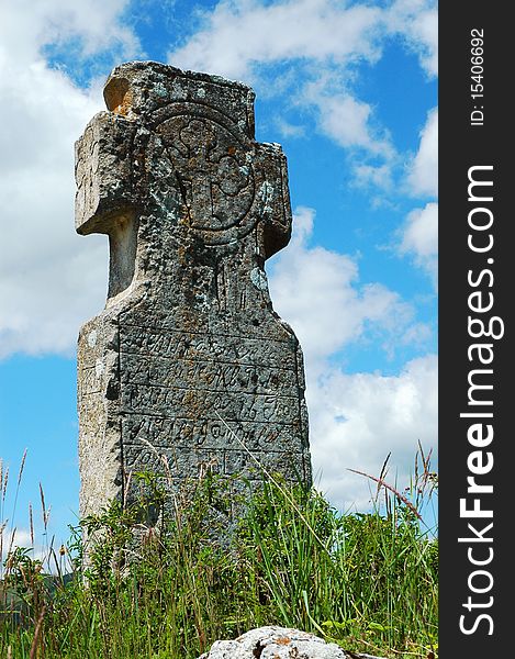 Religious stone cross with beautiful blue sky