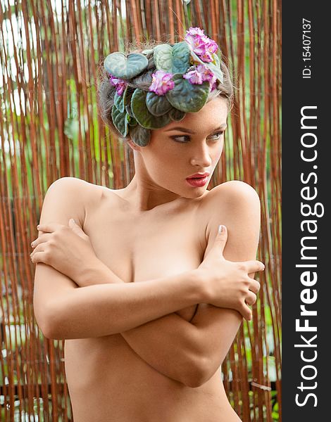 Nude girl with a wreath of flowers on her head
