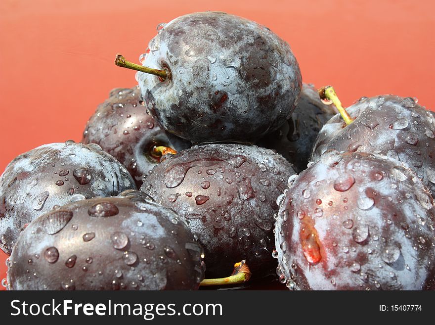 Fresh plums on red background. Fresh plums on red background.