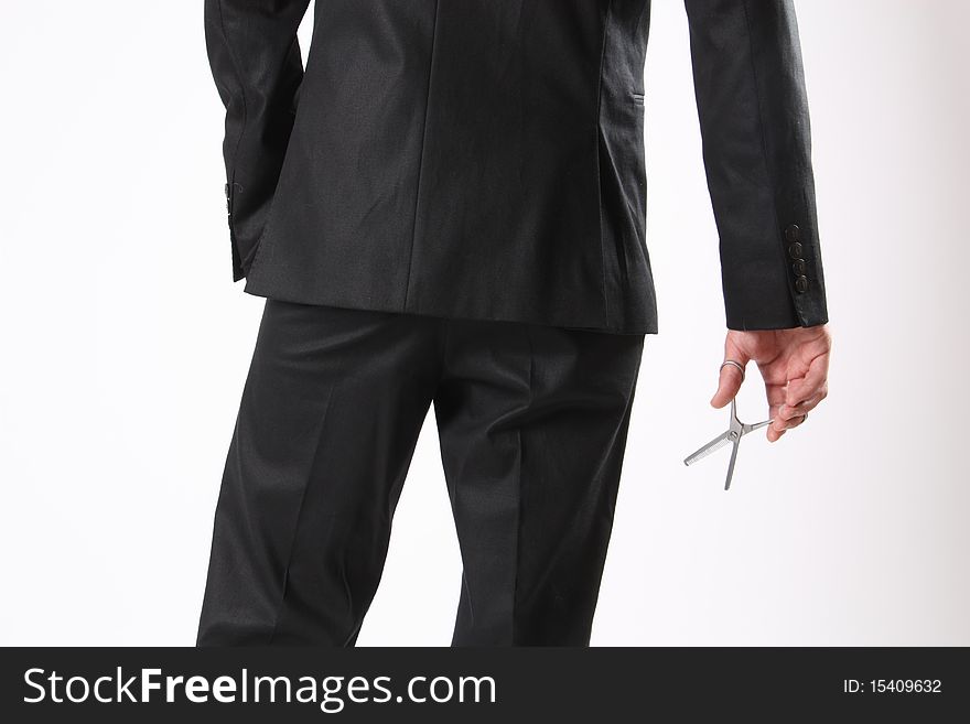 A back of a man holding a scissor in his hand. A back of a man holding a scissor in his hand