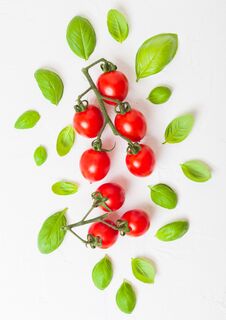 Organic Cherry Sugardrop Tomatoes On The Vine With Basil And Pepper On White Kitchen Background Stock Photography Organic Cherry Sugardrop Tomatoes On The Vine With Basil And Pepper On White Kitchen Background Stock Photography