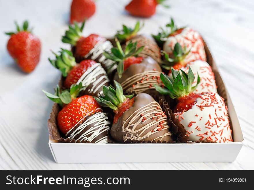 Ripe tasty strawberries covered with white and brown chocolate