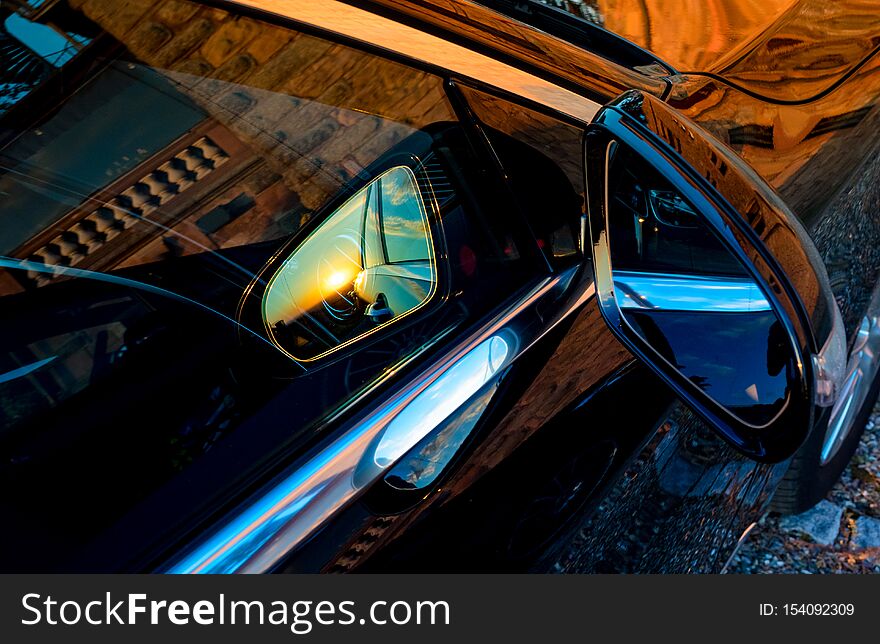 Luxury car mirror with sunset reflection