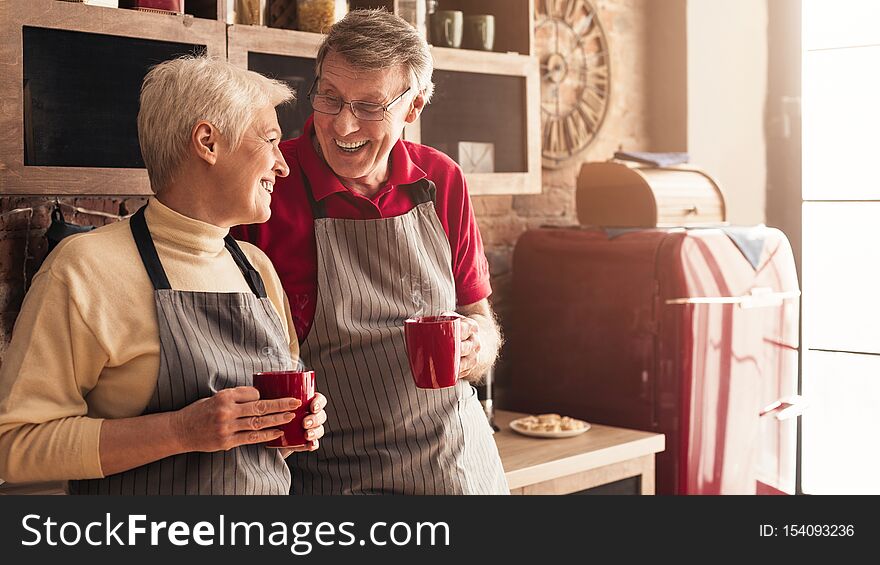 Mature couple in love start new day with fresh coffee at kitchen, panorama, empty space