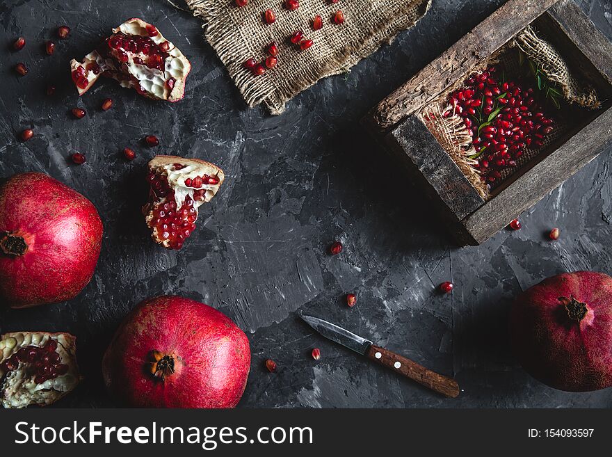 Beautiful composition of pomegranates on a dark background with a towel, healthy food, fruit a