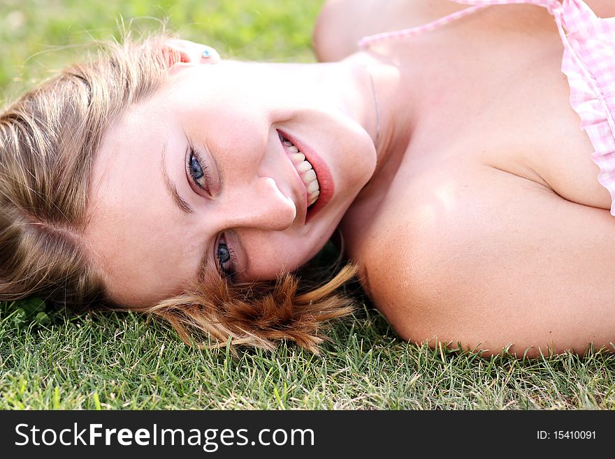 Cute young female lying on grass field at the park. Cute young female lying on grass field at the park