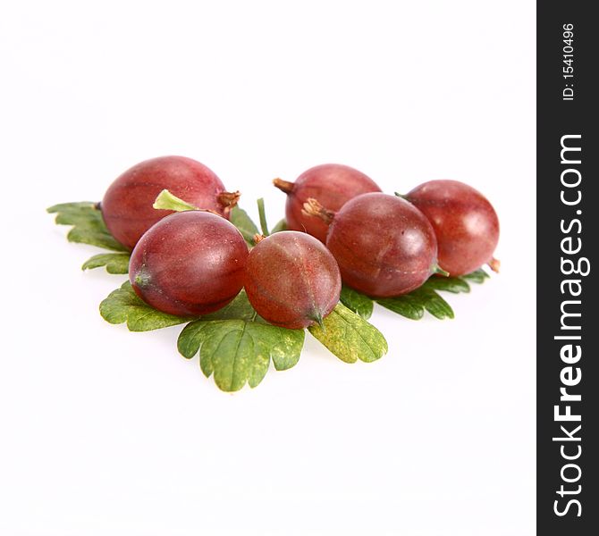 Red gooseberries on a leaf on white background