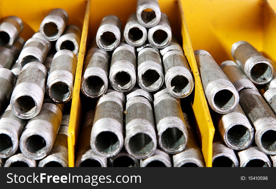 Iron pipes in a yellow shelf, Metallic products. Iron pipes in a yellow shelf, Metallic products