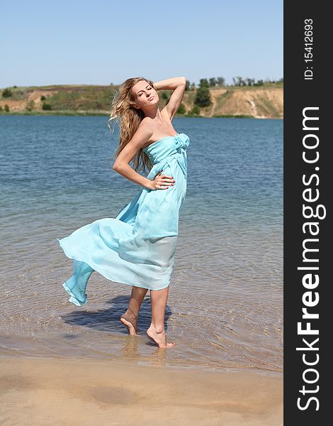 Beautiful blond girl in the sunny day on the lake