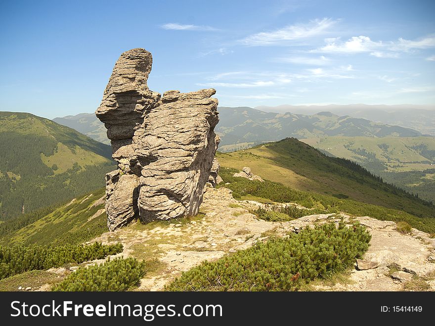 A mountain scene with a strange looking rock cliff. A mountain scene with a strange looking rock cliff