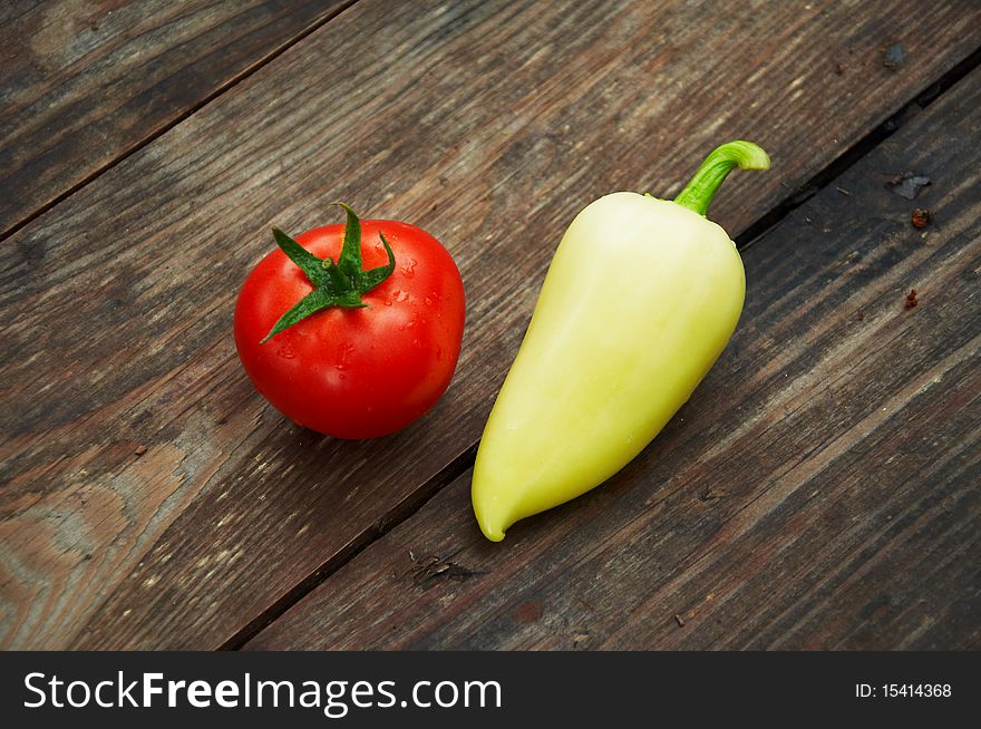 Fresh tomatoes with yellow pepper on a wooden table. Fresh tomatoes with yellow pepper on a wooden table
