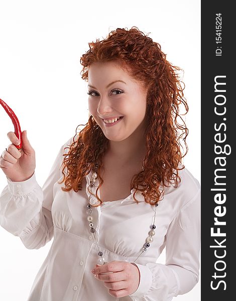 Cute and beautiful young caucasian girl with natural red hair demonstrating shocking chilly red pepper with positive facial expression standing isolated on white. Cute and beautiful young caucasian girl with natural red hair demonstrating shocking chilly red pepper with positive facial expression standing isolated on white