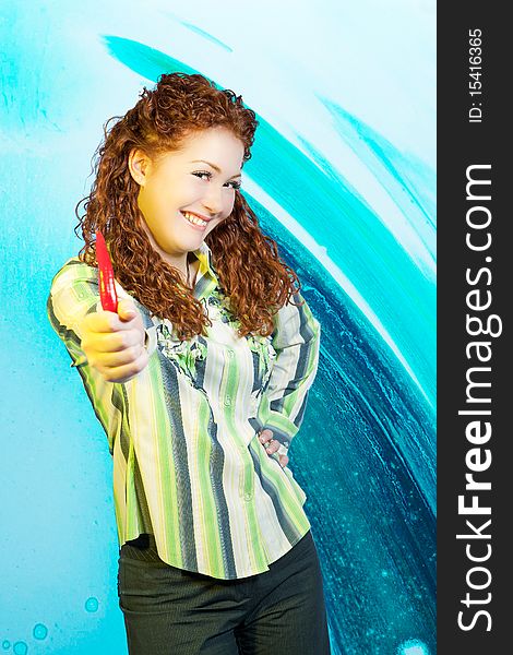 Young smiling and cheerful red aired girl with spicy red pepper in front standing over blue background. Young smiling and cheerful red aired girl with spicy red pepper in front standing over blue background