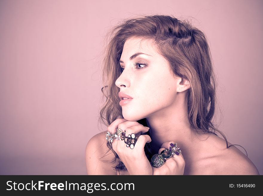 Head and shoulder portrait of a beautiful young woman wearing ornate rings on her fingers. Horizontal shot. Head and shoulder portrait of a beautiful young woman wearing ornate rings on her fingers. Horizontal shot.