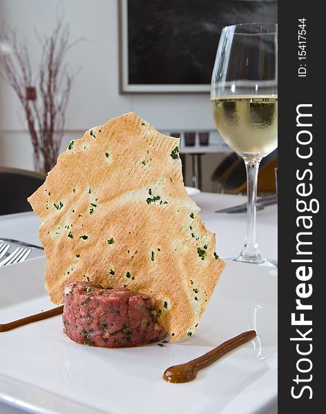 Steak tartare with a tortilla chip and wine