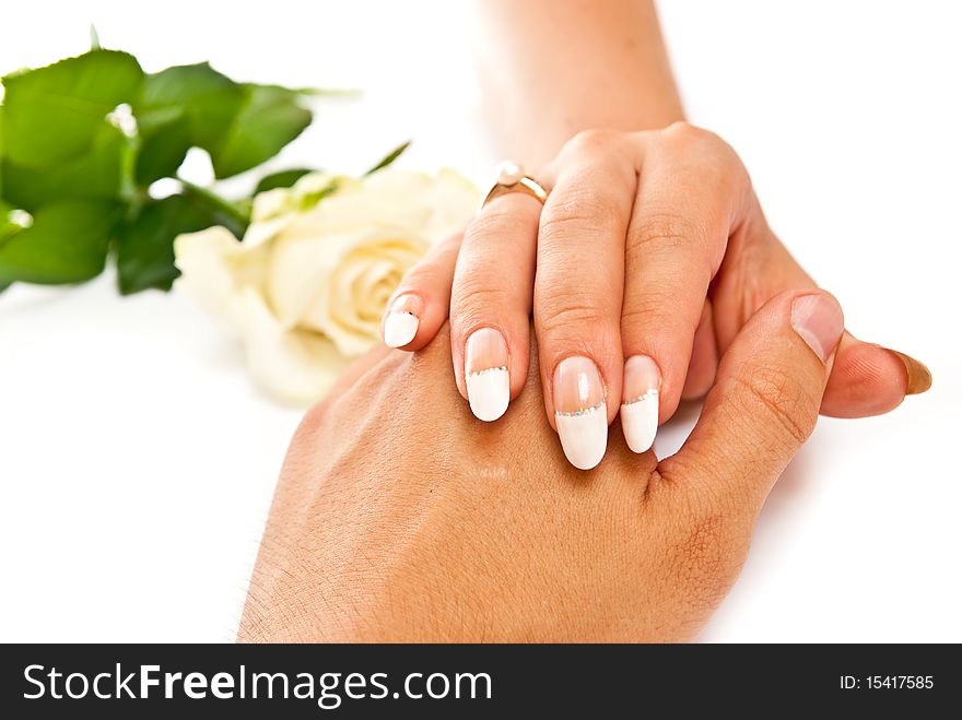 Woman's hand on man's with golden ring on white background. Woman's hand on man's with golden ring on white background