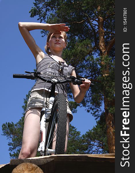 Young and beautiful woman on a bicycle in a sunny day.