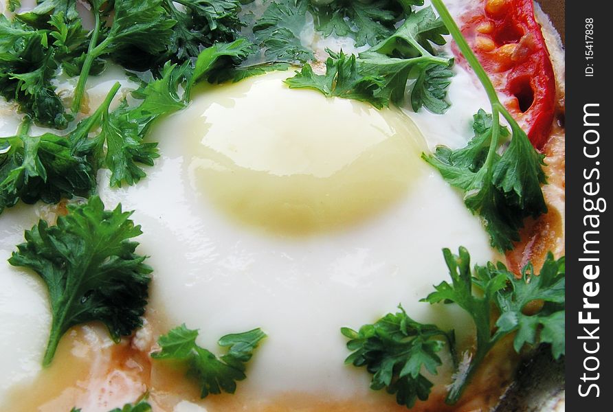 Fried egg with a crust a tomato and parsley. Fried egg with a crust a tomato and parsley