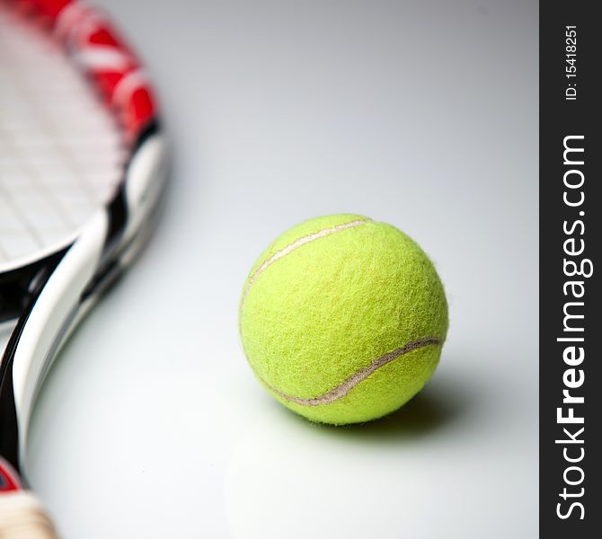 Tennis ball and racket on white background