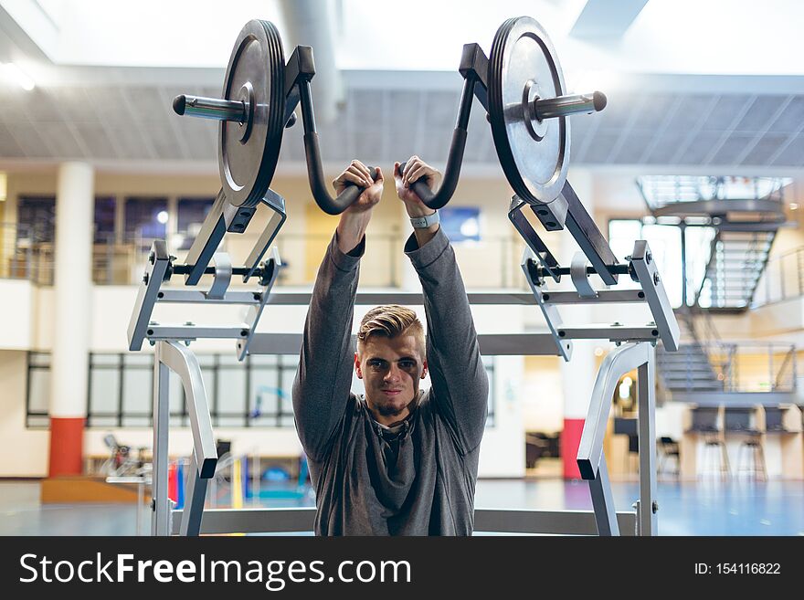 Man exercising with shoulder machine in fitness studio