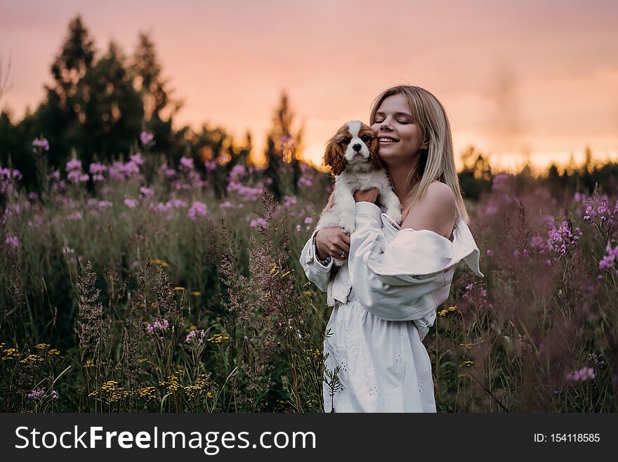 Young Beautiful Women Hugging With The Cocker Spaniel Dog On The Sunset. Outdoor