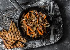 Slow Cooker Braised Beef With Onions And Carrots In A Pan On A Dark Background, Top View Royalty Free Stock Image