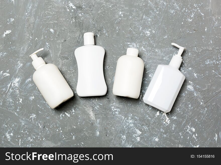 Set of White Cosmetic containers isolated on yellow background, top view with copy space. Group of plastic bodycare bottle