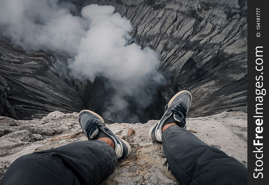 Feet on the edge of a volcano crater
