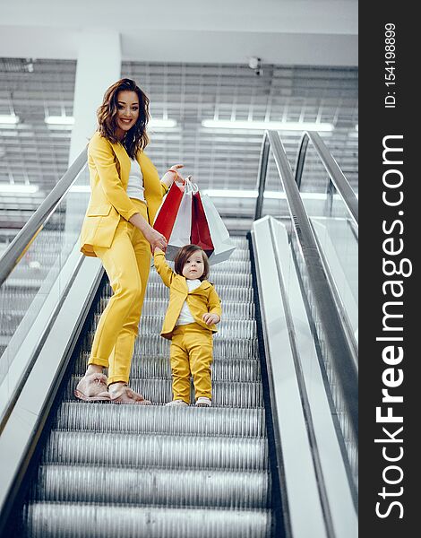 Beautiful girl in a shopping center. Lady with shopping bags. Mother with daughter in stylish clothes. Beautiful girl in a shopping center. Lady with shopping bags. Mother with daughter in stylish clothes