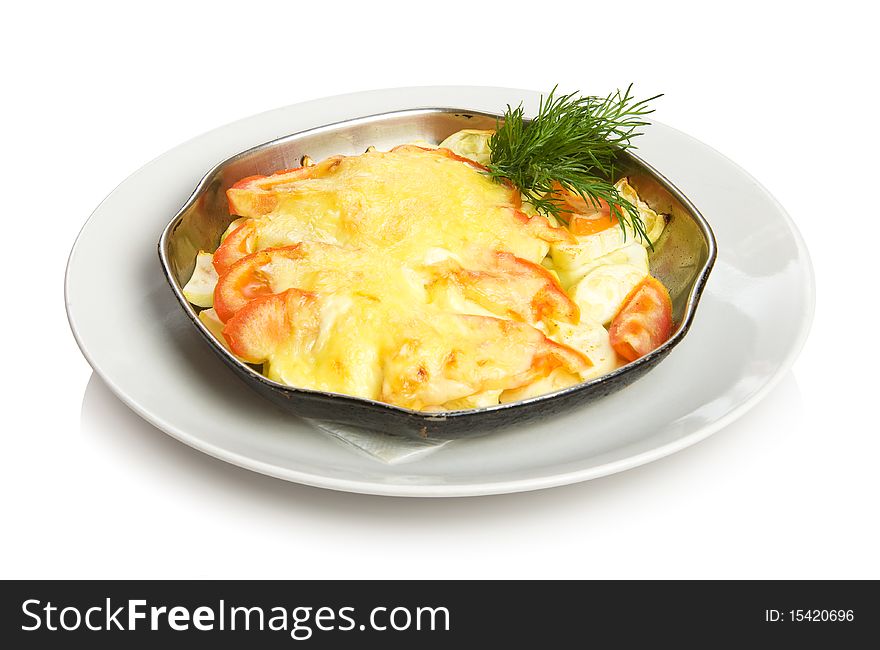 Baked vegetables - zucchini and tomatoes with cheese.
Isolated on white.