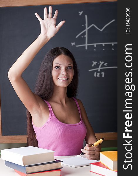 High school student with her hand raised to ask a question