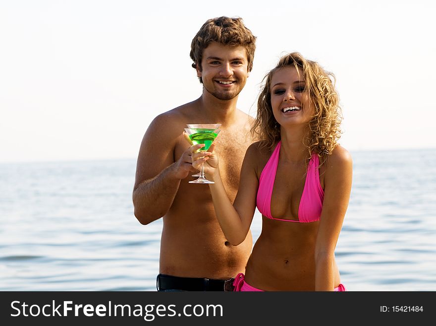 Young couple on the seaside with cocktails