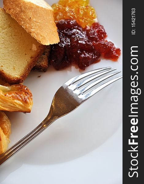 Bread and jam as breakfast, with a fork in plate.