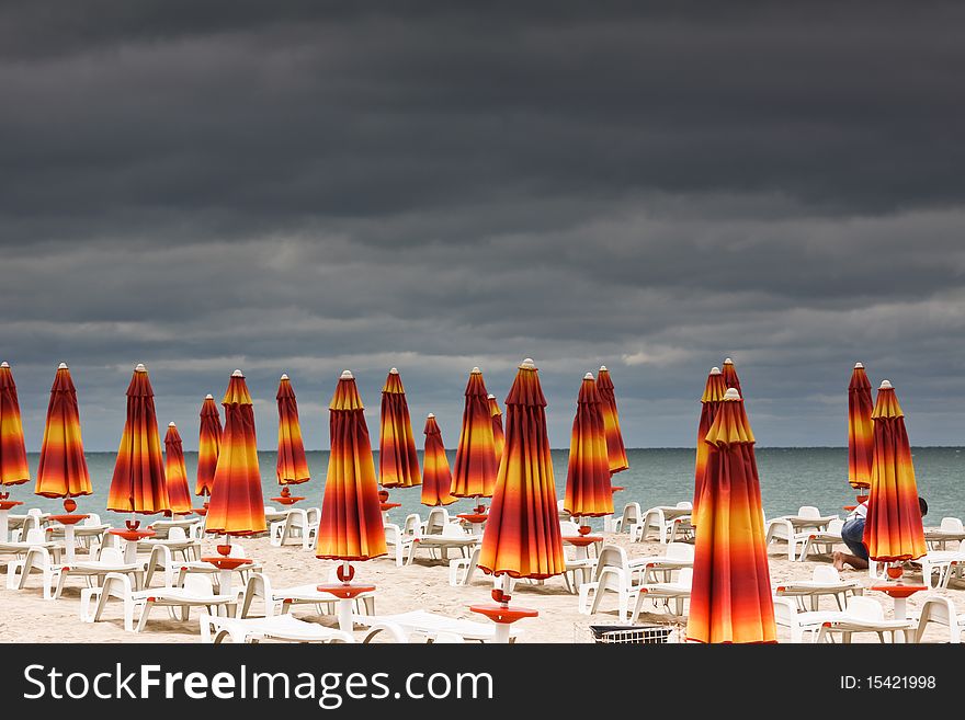 Beach with deckchairs and parasols with sea. bad weather. Beach with deckchairs and parasols with sea. bad weather