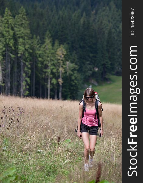 Young woman hiking outdoors (going uphill)