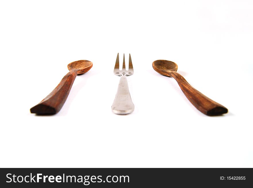 A group of wood teaspoons and a silver fork on white background. A group of wood teaspoons and a silver fork on white background