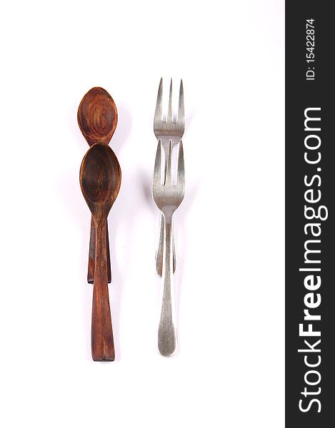 A group of wood teaspoons and  silver forks on white background. A group of wood teaspoons and  silver forks on white background