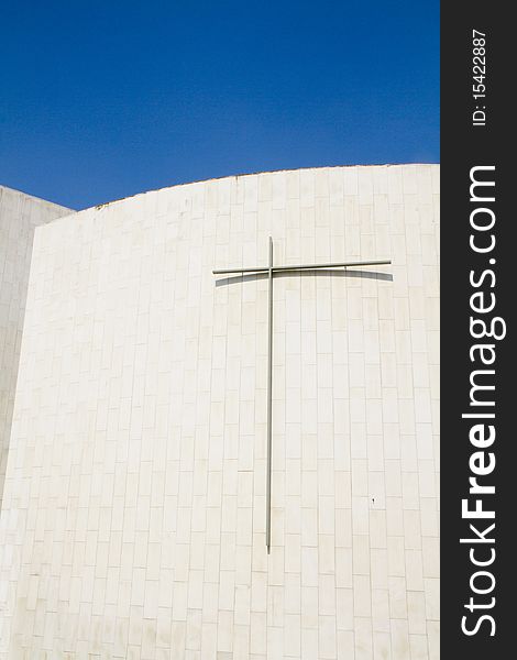 Crucified on a white wall and blue sky