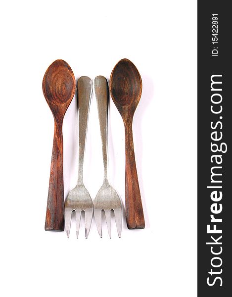A group of wood teaspoons and silver forks on white background. A group of wood teaspoons and silver forks on white background